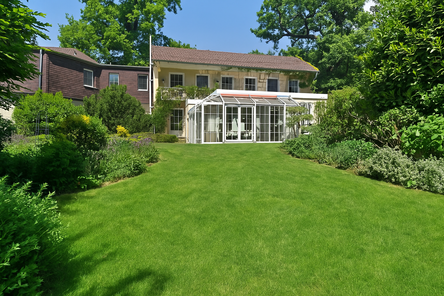 Gartenansicht Haus (Rasen aufgrund defekter Bewässerungsanlage mit KI überarbeitet)
