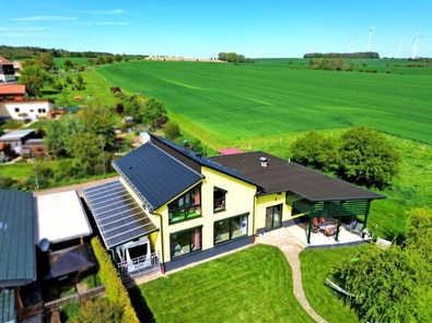 Blick auf die Immobilie und die angrenzenden Felder und Wiesen