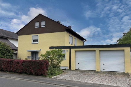 Straßenansicht mit Doppelgarage und integriertem Hauswirtschaftsraum