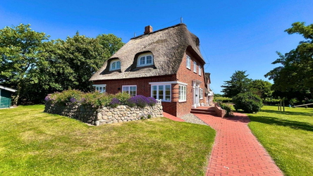 Inbegriff norddeutscher Architektur – Traditionelles Reetdachhaus mit rotem Klinker