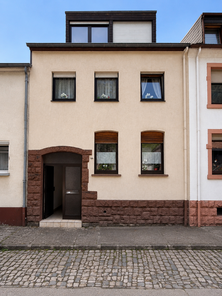Symmetrische Reihenhausfassade an ruhiger Straße.p