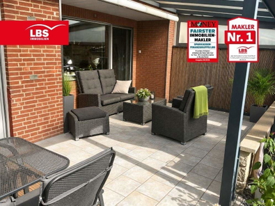 Überdachte Terrasse mit Photovoltaikanlage und Blick in den gepflegten Garten