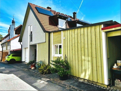 Fassade mit Putz und Holz... die Westansicht des Hauses mit integrierter Garage