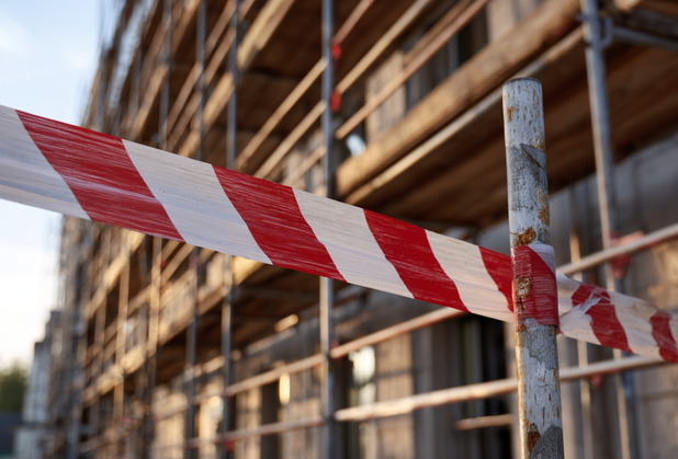 Vor einer Immobilie ist ein rot-weißes Absperrband.