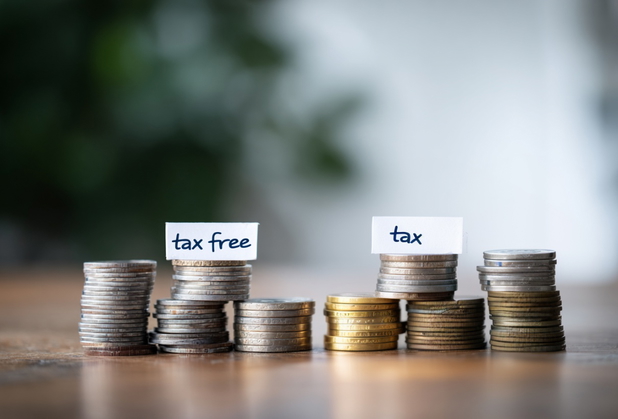 Zwei M&uuml;nzenstapel, der erste hat ein Schild "tax free", der zweite Stapel hat ein Schild mit "tax".