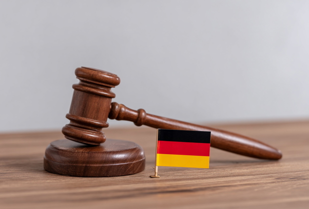 Ein hölzerner Richterhammer neben einer kleinen Deutschlandflagge.