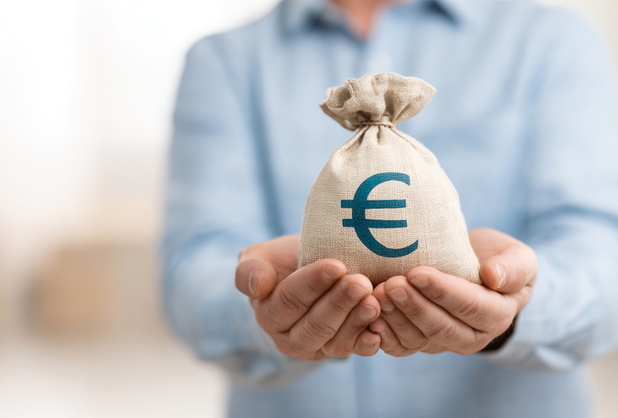 Ein Mann hält einen Geldsack in den Händen, auf dem ein Euro-Zeichen ist.