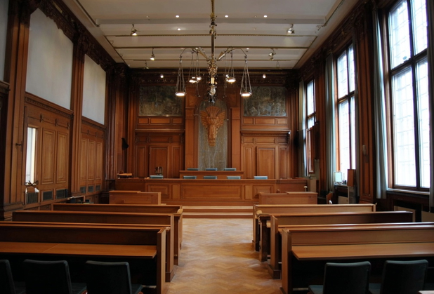 Ein Gerichtssaal in dunklem Holz.