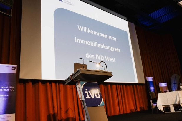 Eine Leinwand, auf der steht: Willkommen zum IVD West Immobilienkongress