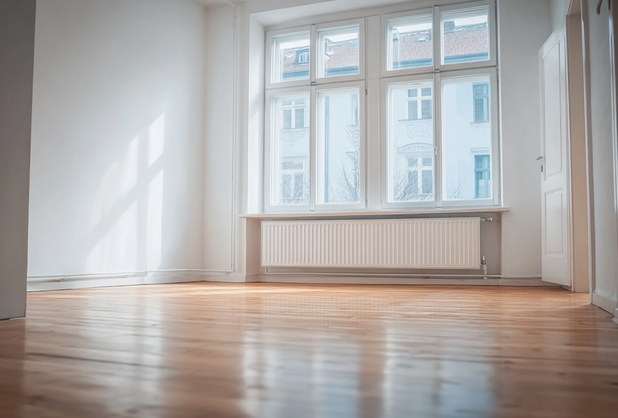 Eine leere Altbauwohnung mit Parkettboden.