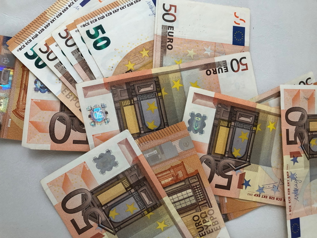 Fünfzig-Euro Scheine, die verteilt auf einem Tisch liegen.