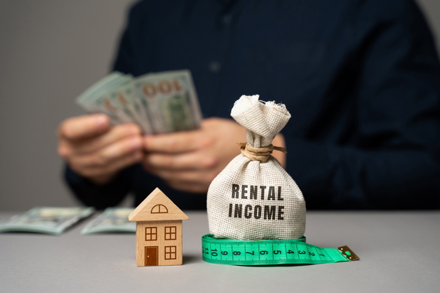 Ein Vermieter zählt Geldscheine, im Vordergrund liegt ein Geldsack mit "Rental Income" drauf.