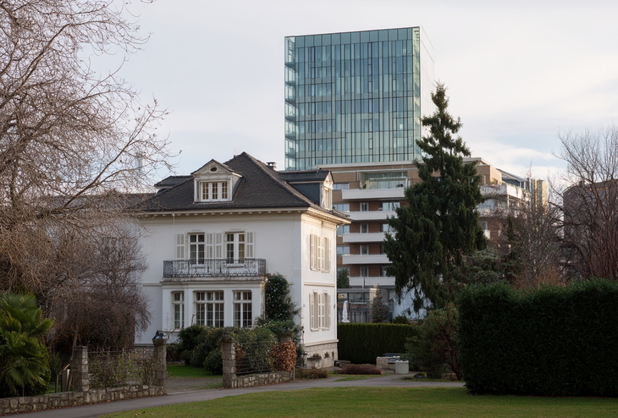 Eine Villa, dahinter ein Wohnhaus und dahinter ein Hochhaus.