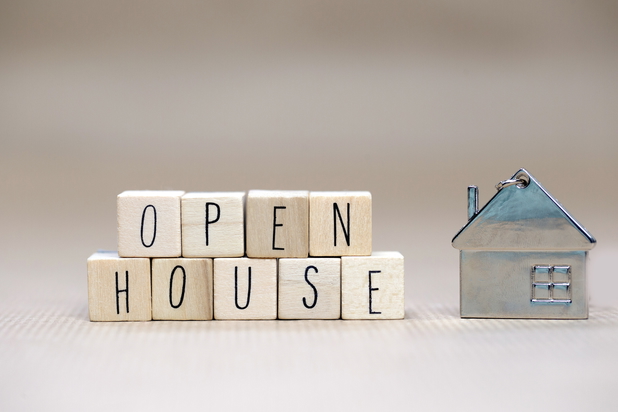 Würfel mit Buchstaben, die das Wort Open Houses beschreiben und ein Holzhaus daneben