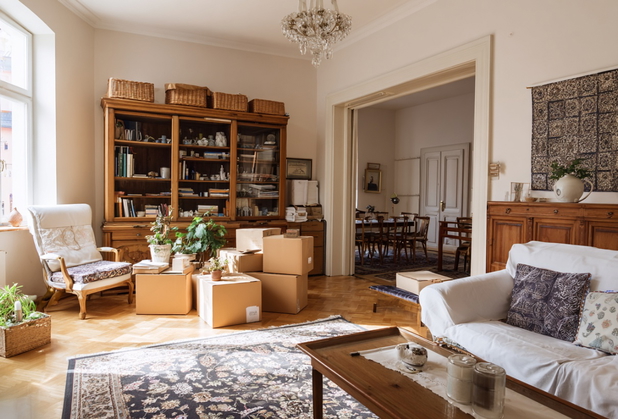 In einem Wohnzimmer eines Rentners stehen einige Umzugskartons.