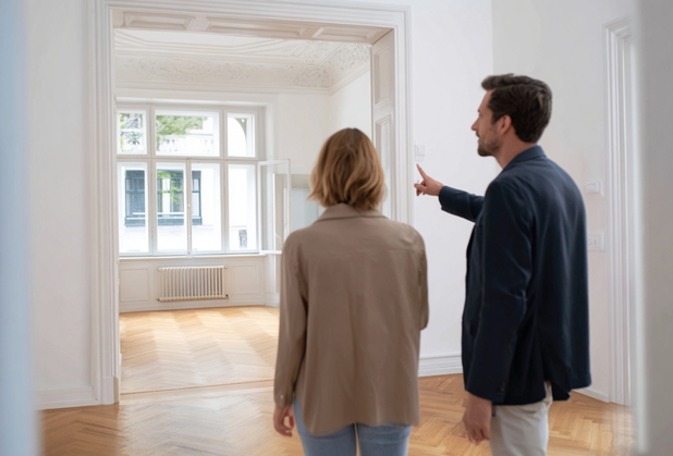 Ein Mann und eine Frau besichtigen eine Altbauwohnung.