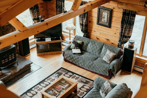 Ein gemütliches Wohnzimmer mit Holzboden- und Wänden und zwei grauen Sofas.