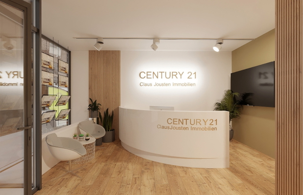 Eingangsbereich von Century21 mit Empfangstresen und kleinem Wartebereich.