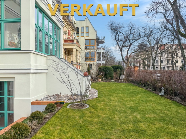 Seitenansicht eines Hauses mit großen Fensterfronten und Blick auf den Garten.