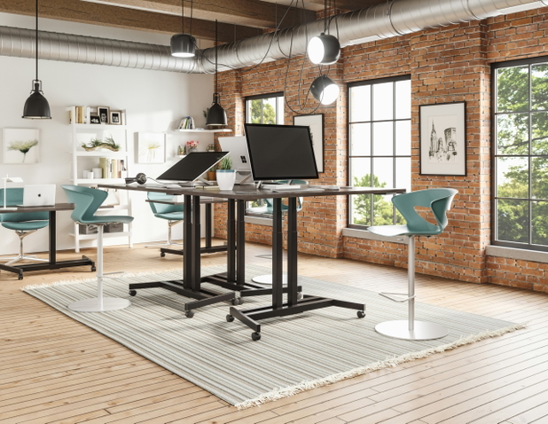 Ein modernes Büro mit industriellem Einrichtungsstil, in der Mitte des Raumes stehen einige Stehschreibtische.
