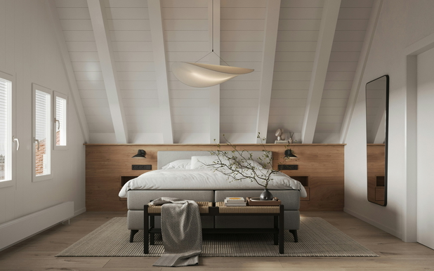 Ein breietes Schlafzimmer mit einem Doppelbett in der Mitte, über dem eine Deckenlampe hängt.