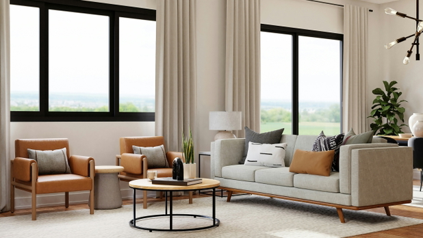 Ein helles Wohnzimmer mit einer Couch, zwei Sesseln und großen Fenstern.