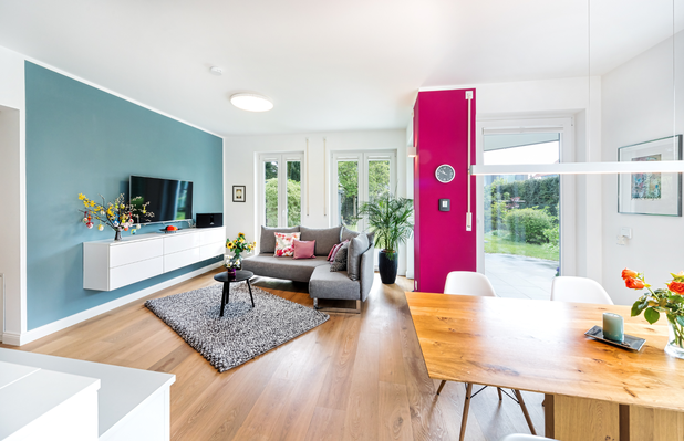 Ein modern eingerichtetes Wohnzimmer mit bunter Wandfarbe.