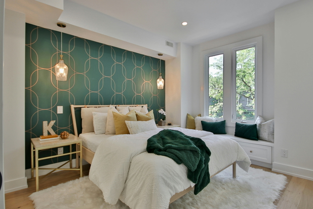 Ein Schlafzimmer mit einem weißen Bett und grüner Wand.