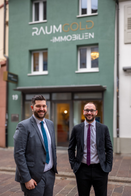 Die beiden Gründer von Raumgold Immobilien vor ihrem Büro.