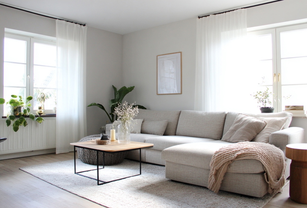 Ein stilvoll eingerichtetes Wohnzimmer mit hellen Sitzmöbeln und Teppich.