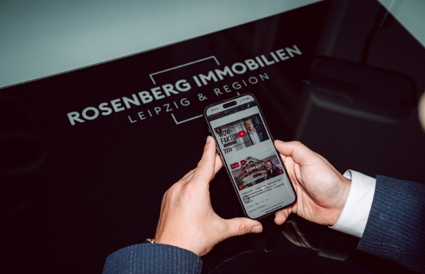 Ein Handy vor dem Rosenberg Immobilien Logo.