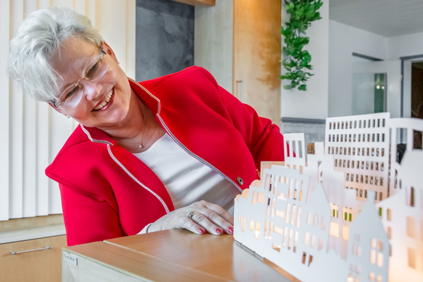 Inhaberin Christiane Starke, wie sie auf ein Modell einer Immobilie schaut. 
