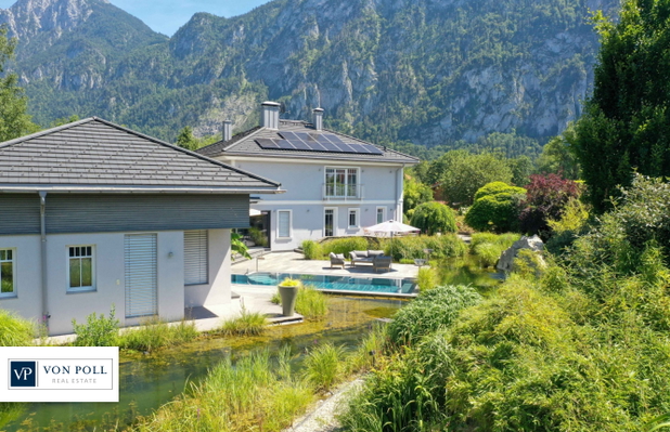 Haus mit Pool und großem Garten umgeben von Natur und Bergen.