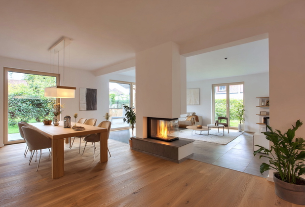 Ein modernes Ess- und Wohnzimmer, welches von einem Kamin getrennt wird.