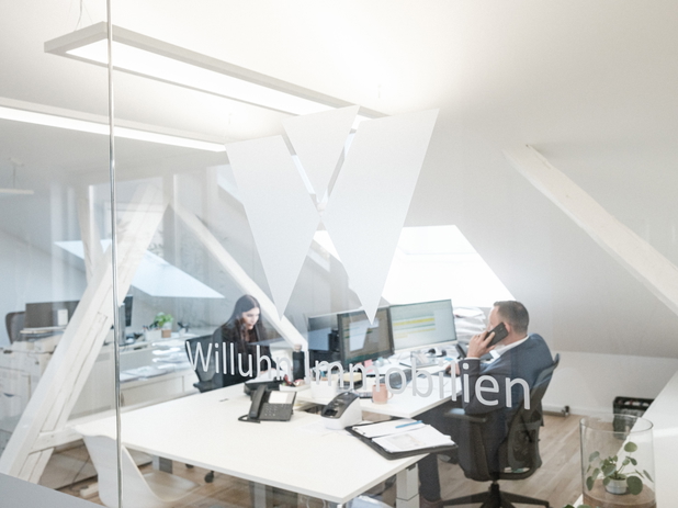 Das Büro von Willuhn Immobilien, zwei Mitarbeiter telefonieren.